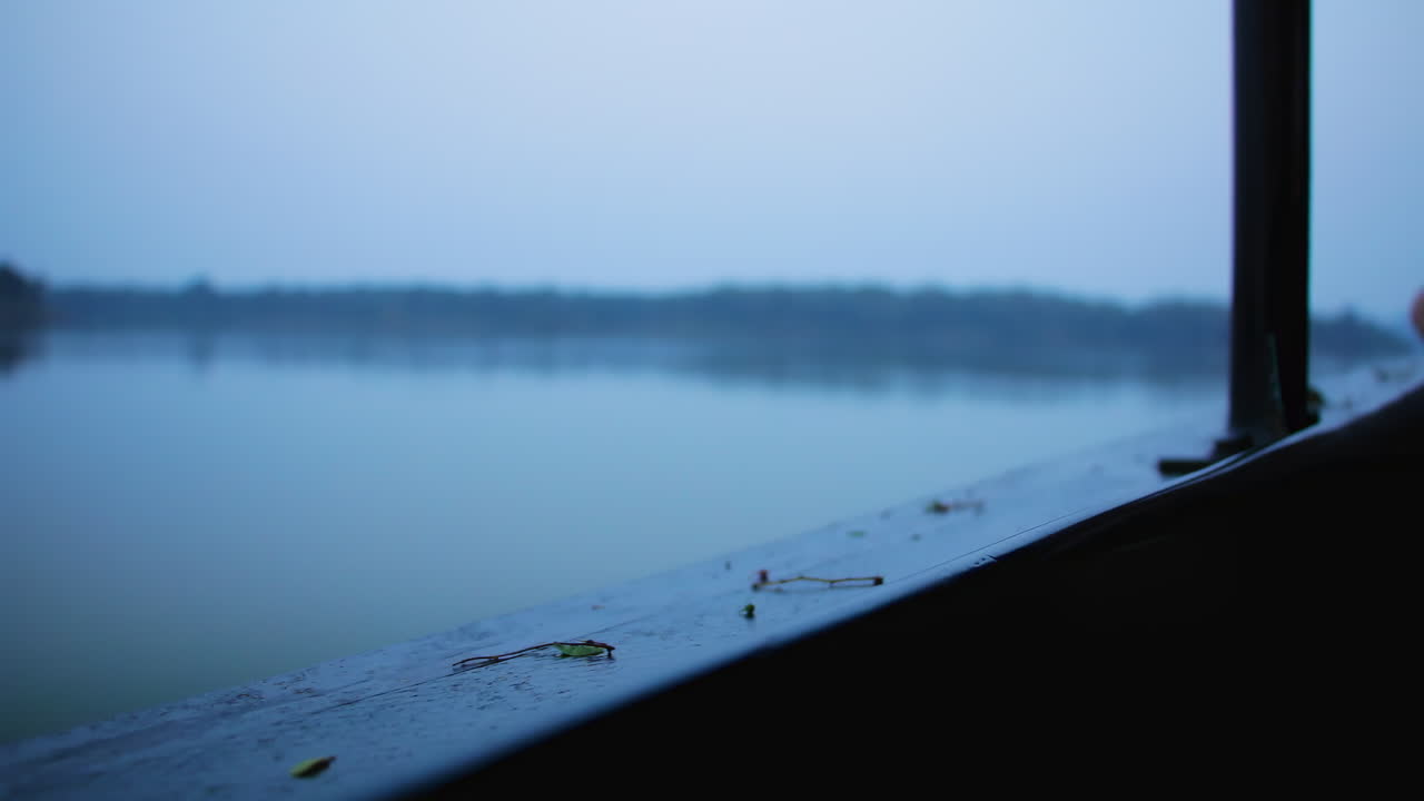 Blurred background falling rain on the Kabini river in Nagarhole national park, Boat side foreground