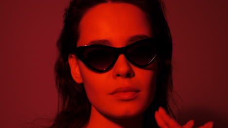 woman in red light with sunglasses