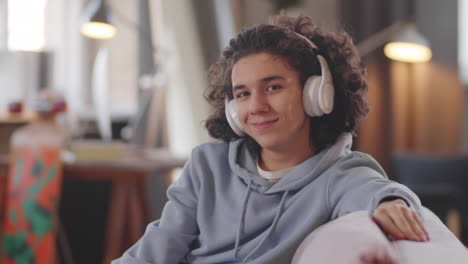 portrait of cheerful teenager in headphones at home