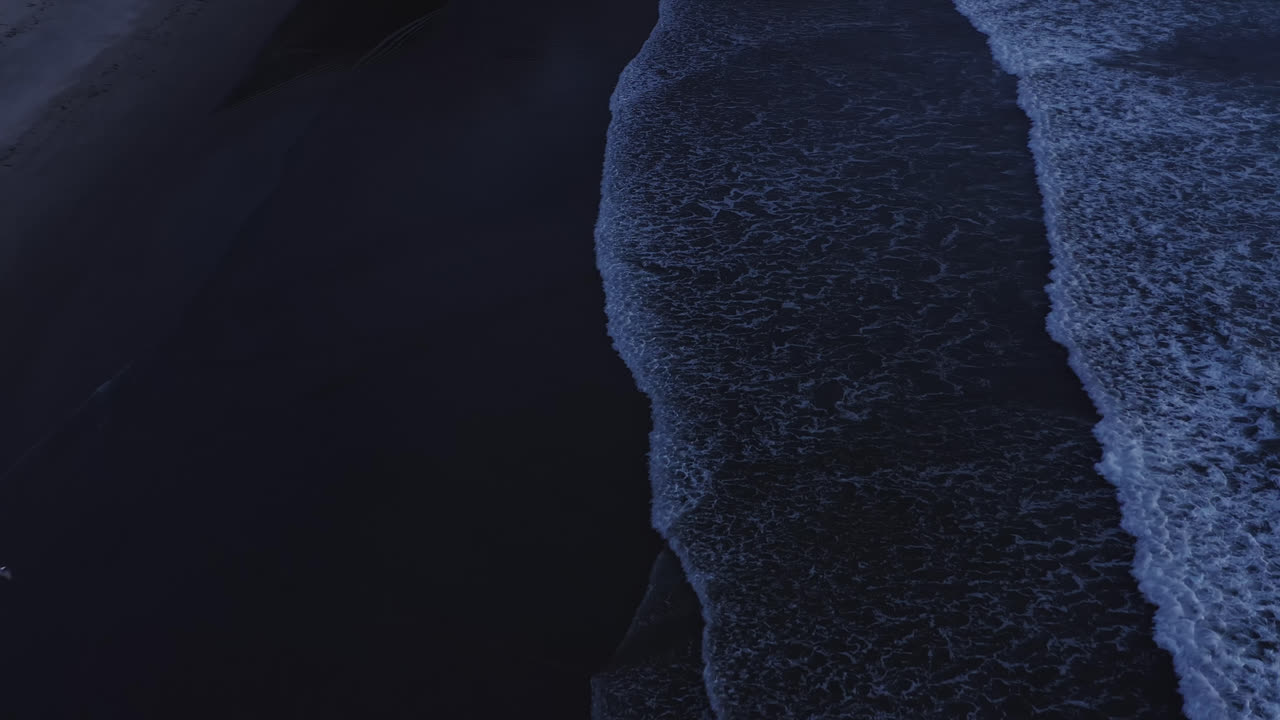 Calming, aerial view of ocean waves rolling towards beach on Oregon Coast