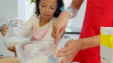 Black-mother-and-daughter-preparing-food-in-kitchen-4k