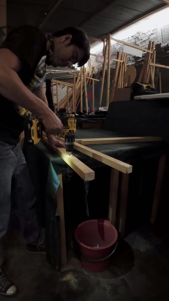 Man Drilling Holes into Wooden Beam in Workshop