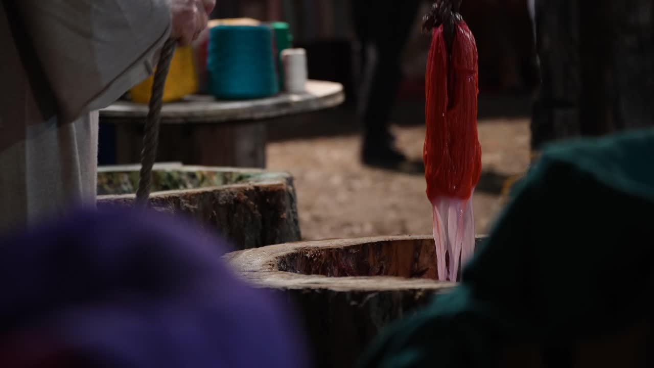 Processo di tintura colorato a mano di fibre tessili per la tessitura tradizionale di tappeti