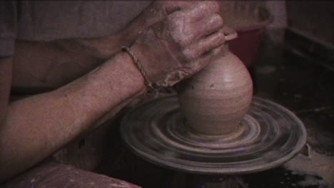 the potter makes a jug of clay. vintage effect. a man makes a vase on a potter's wheel