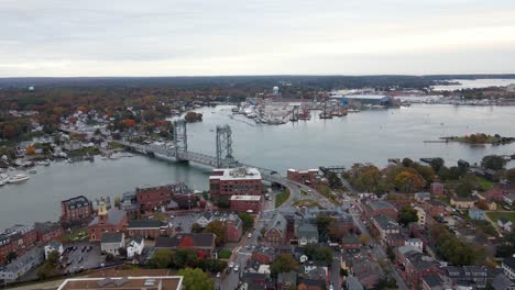 aerial view overlooking the piscataqua river and the cityscape of cloudy portsmouth city - pan, drone shot