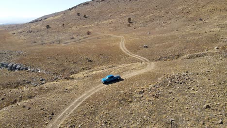 Rancher-looking-for-cattle-on-a-dry-pasture-during-a-drought---driving-truck-on-a-dirt-road