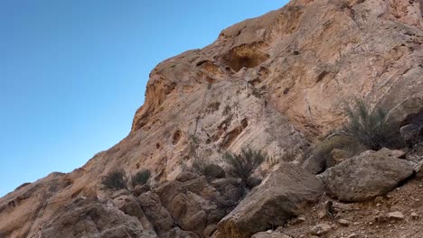 Casa-Nómada-Hecha-A-Mano-Tallada-En-Un-Acantilado-De-Roca-En-La-Naturaleza-El-Histórico-Agujero-Hecho-Por-El-Hombre-En-La-Montaña-De-Roca-Vida-Tradicional-En-Un-Paisaje-Natural-Salvaje-árbol-Frutal-De-Higo-Crece-En-El-Cielo-Azul-De-Irán-Vista-Panorámica-Rocosa