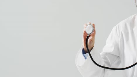 video of midsection of caucasian doctor holding stethoscope, with copy space