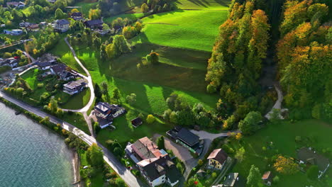 A-Reverse-Shot-Of-A-Small-Village-On-A-Green-Landscape-On-A-Hill-By-The-Lake-In-Austria