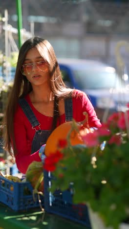 joven recogiendo calabazas en un mercado de otoño