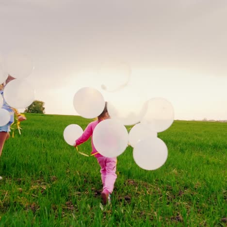 Two-Carefree-Gay-Children-Are-Hurrying-Over-A-Green-Meadow-With-Balloons