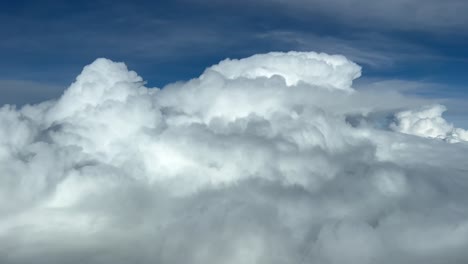 impresionante vista aérea desde la cabina de un jet durante el nivel de crucero sobrevolando un cielo nublado lleno de cumulonimbus