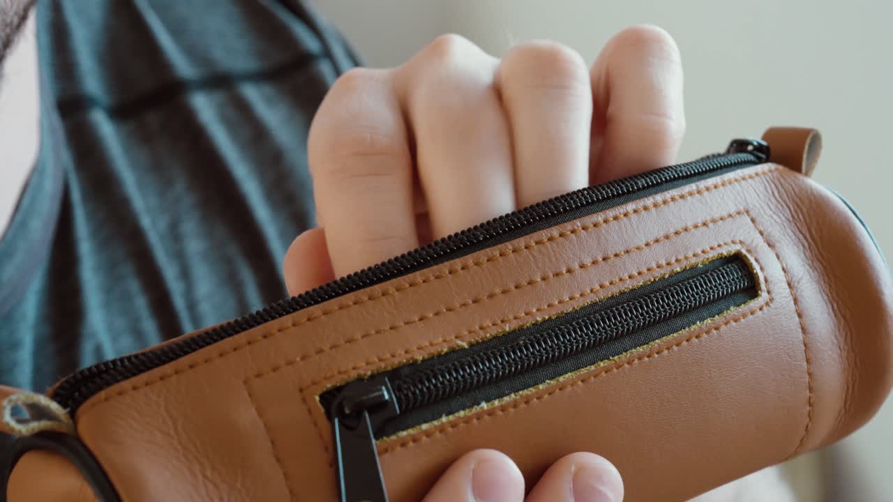 Primo piano di uno studente che estrae un bigliettino nascosto da un astuccio durante un esame. Concetto di barare a scuola, frode agli esami, disonestà accademica e appunti segreti.