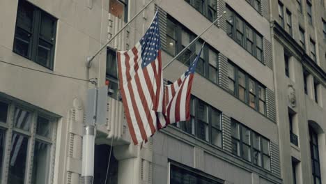 slow motion united states flag hanging in the buildings of wall street district in new york city