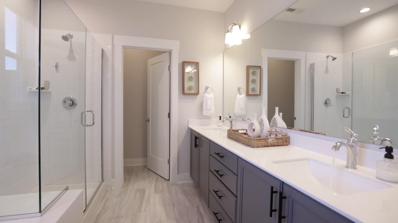 un baño moderno y de lujo con un interior blanco, una ducha con una pared divisoria de vidrio, un espejo con iluminación