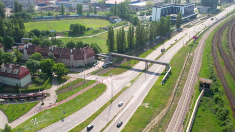 arriba abajo aéreo - tráfico de la ciudad en gdansk en el distrito de wrzeszcz con vistas al astillero - una calle concurrida y rutas de transporte interconectadas - coches, tranvías, ferrocarriles