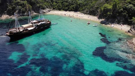 An-old-wooden-ship-anchored-in-a-secluded-spot,-Robinson-beach,-Sithonia,-Greece