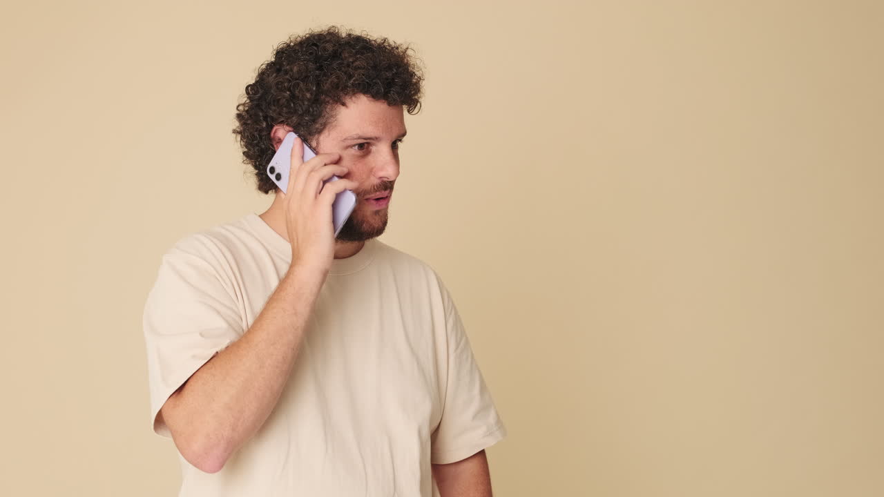 Curly-Haired Man Reacts with Mixed Emotions During Phone Call