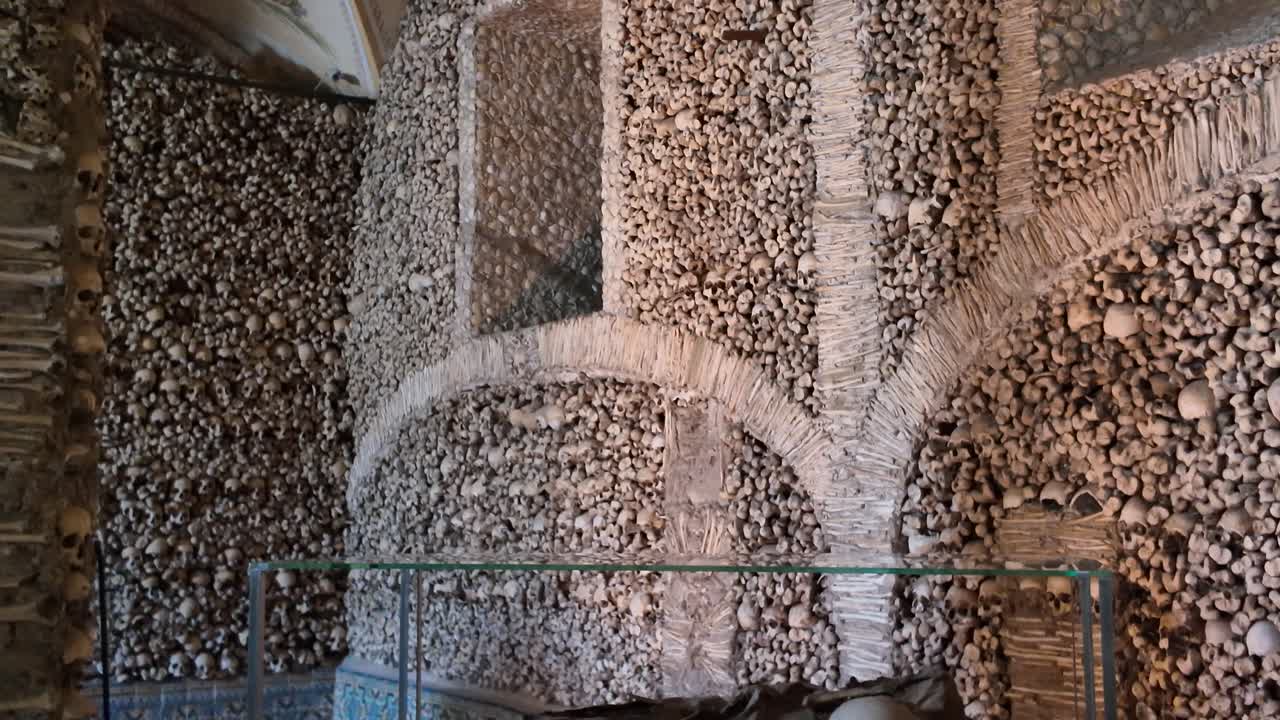 Skeleton displayed inside chapel lined with real human bones in évora portugal