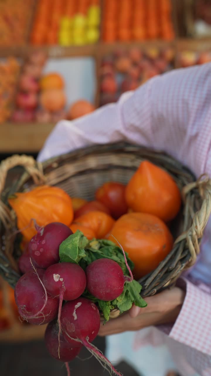 persona que sostiene una canasta de productos frescos en un mercado de agricultores