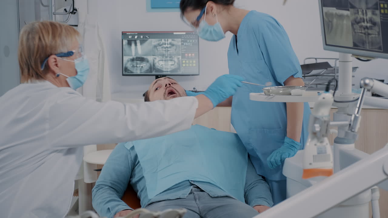 외과적 절차 후 의 치아 를 살펴보는 전문가 들 의 팀