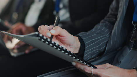 a woman taking notes at a conference