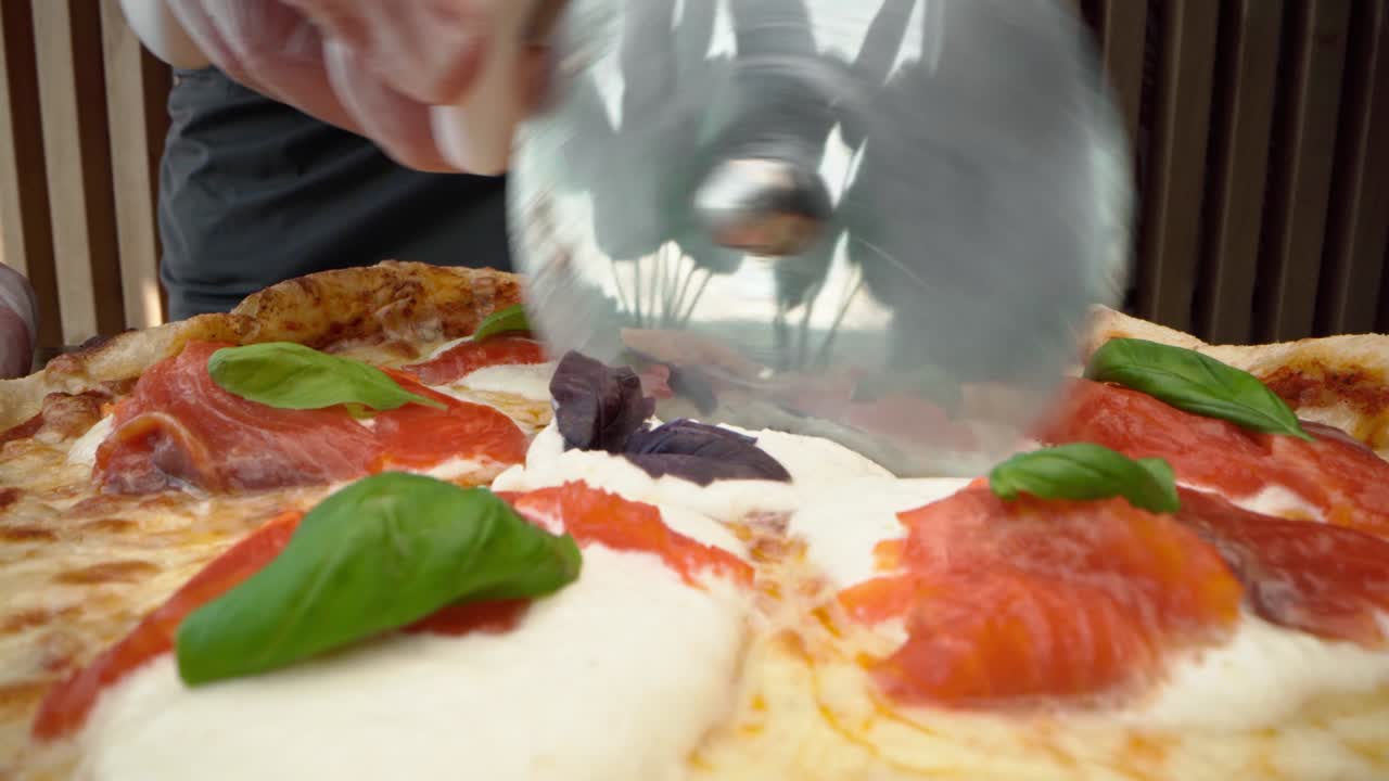 셰프는 둥근 커터로 신선하게 만든 피자를 잘라니다.
