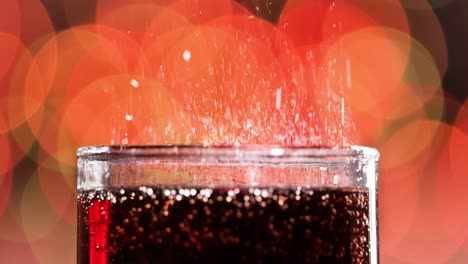 glass of cola. ice cola with splashing bubbles slow motion on a blurry light ,blurry background.