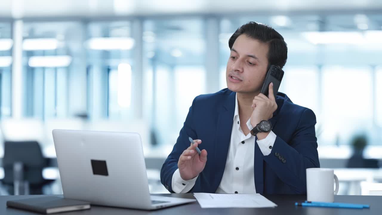 인도인 매니저가 전화로 이야기하고 있습니다.