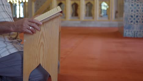 man reading the quran in a mosque