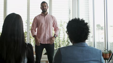 handsome young worker speaking to colleagues