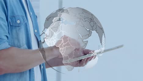 animation of globe over hands of caucasian man using tablet