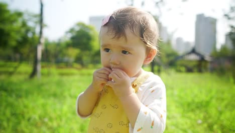 multi-racial asian baby girl toddler playing at a city park is adorable - slow motion