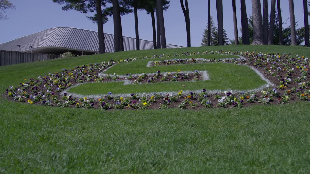 Block S in flowers on the campus of Michigan State University in East Lansing, Michigan with gimbal video moving sideways.
