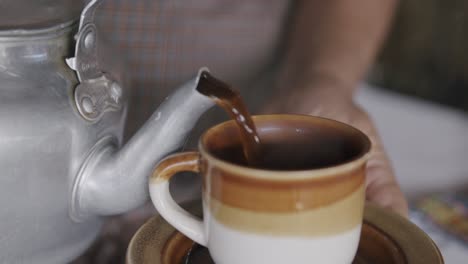 Slow-motion-footage-of-a-worker-on-a-coffee-plantation-pouring-coffee-into-a-mug