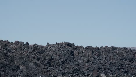 Volcanic-rock,-close-up,-sailing-POV,-windy,-ocean,-Fira,-Santorini,-Islands,-Greece