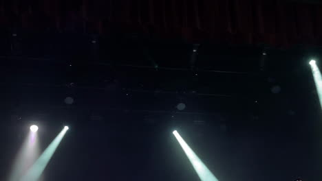 stage lighting beams illuminating a dark theater space creating a dramatic atmosphere