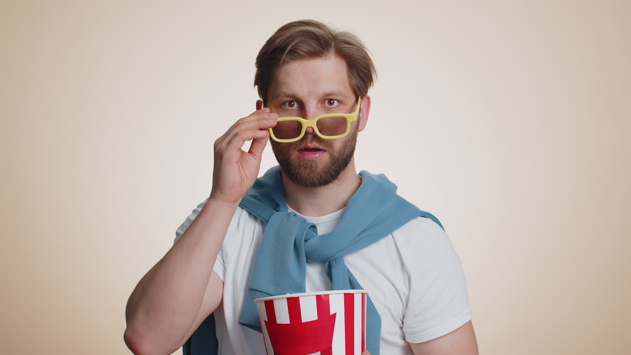 Excited caucasian man eating popcorn watching interesting tv serial sport game film online movie