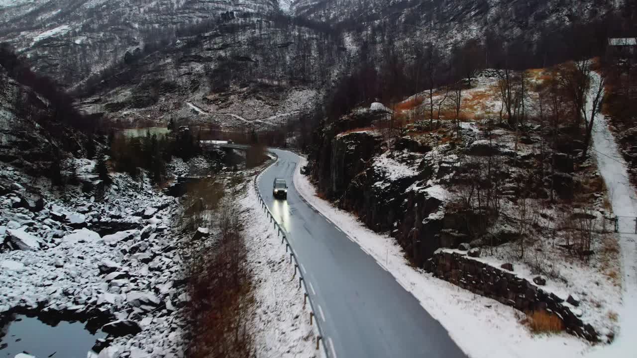 노르웨이 의 눈 인 산악 도로 를 가로질러 캠핑 차 가 운전 하고 있으며, 그 주변 에는 거친 겨울 풍경 이 있다