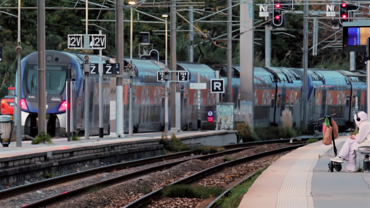 Grey train slowly leaving the Grasse, France station in the evening