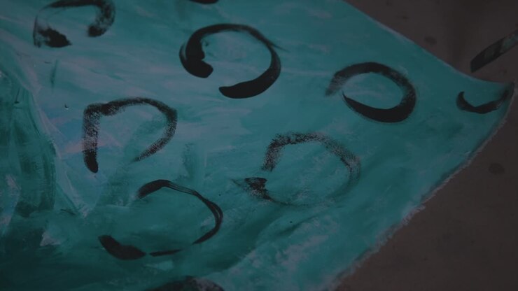Close-up shot of an abstract painter finishing her artwork