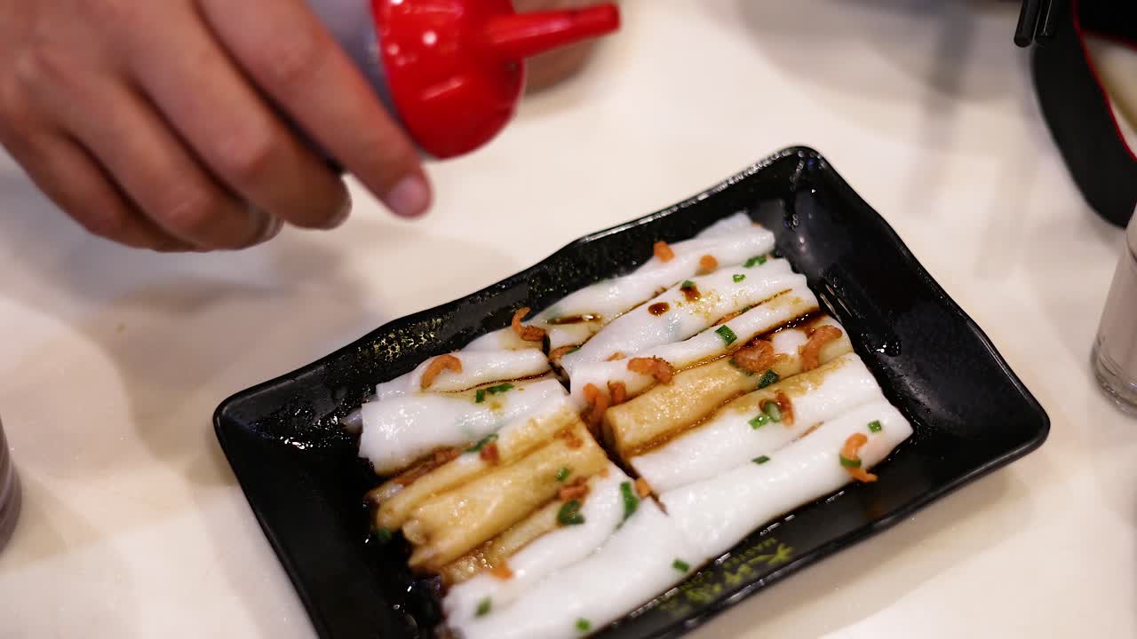 Sauce added to rice noodle rolls in Hong Kong