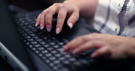 Female-Executive-Working-On-Laptop-At-Workplace