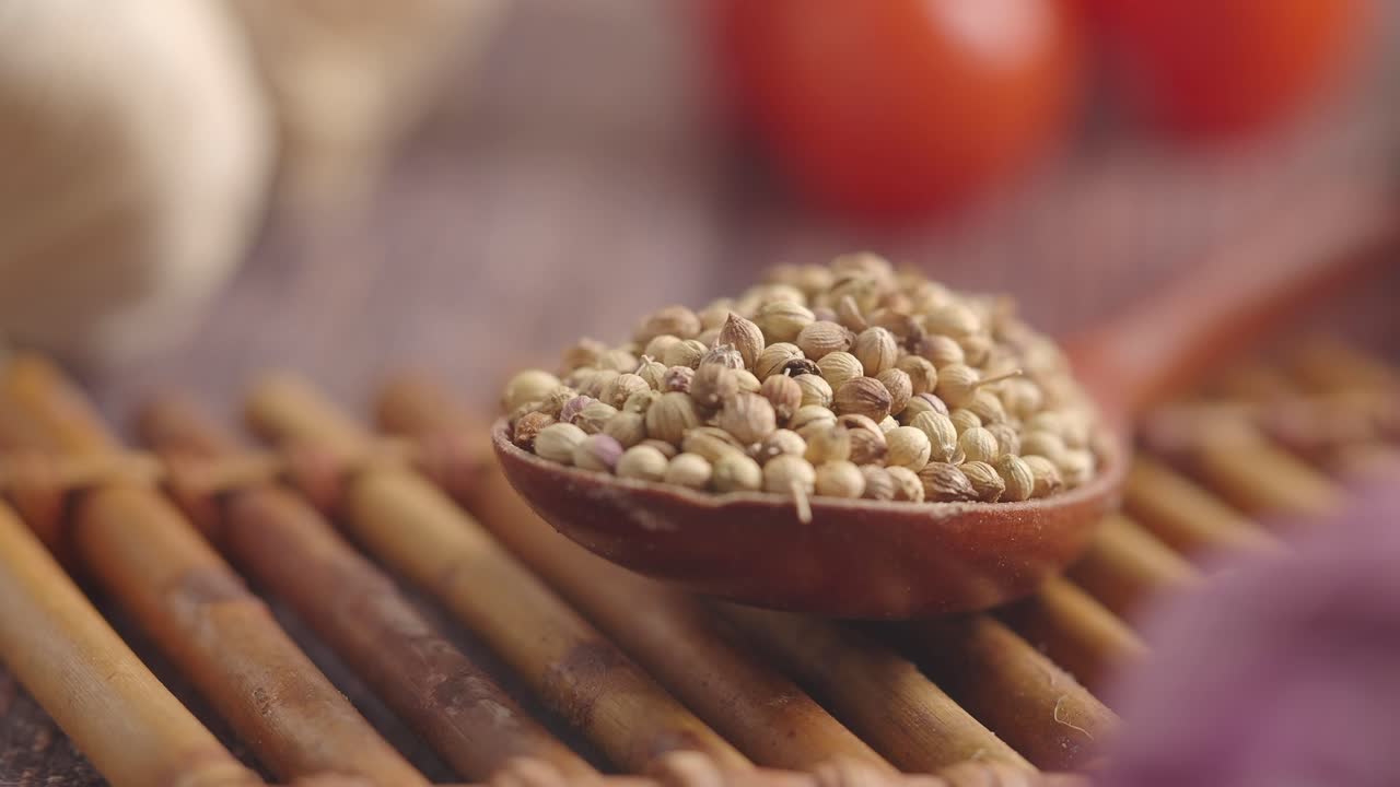 Dried Coriander Seeds in Wooden Spoon on Bamboo Mat