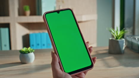businesswoman fingers zooming green screen cellphone at office close up.