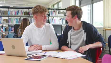 Zwei-Männliche-College-Studenten,-Die-Zusammen-In-Der-Bibliothek-Am-Laptop-Arbeiten