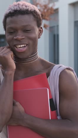transgender person smiling at the camera standing in a university campus