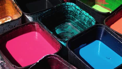 traditional fabric dye in a variety of colours in plastic containers ready for use