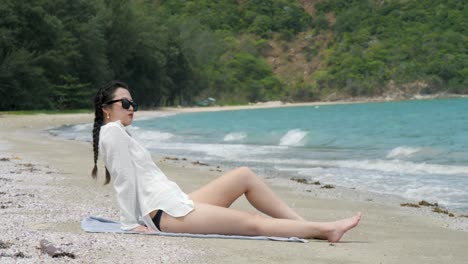 incoming gentle tide, beach location, young woman unwinds, slow motion