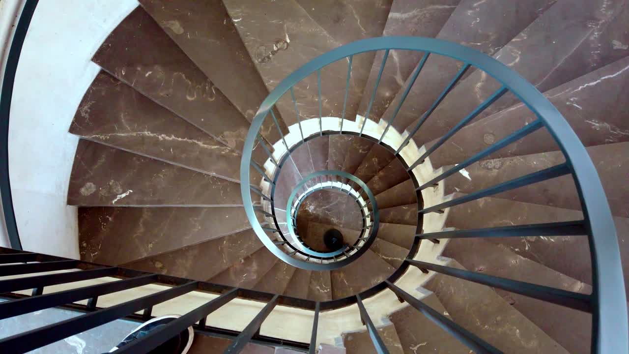 Top view of a spiral staircase with marble steps and metal handrail inside Modern Art Museum Cuernavaca
